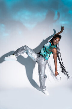 Afro woman dancer posing in studio with dramatic shadow