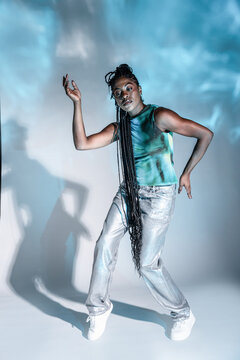 Afro woman dancer posing in studio with dramatic shadow