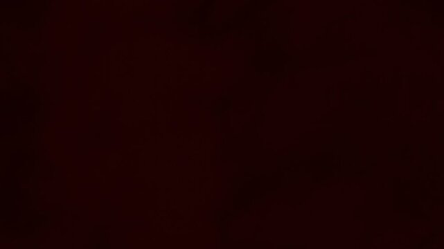 Eerie dark crimson blood red smoke and thick mist seeping across screen in a drifting horror atmosphere seamless loop animation background for cinematic motion graphics and spooky visual design