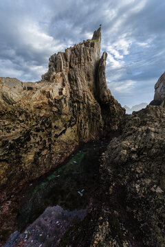 Jagged sea stack and rocky shore on Asturian coast
