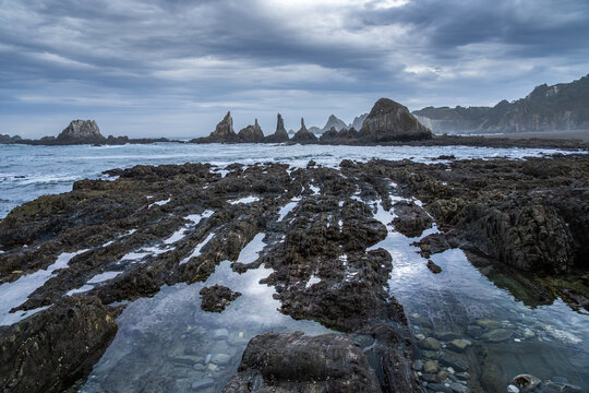 Asturian rocky coast with tide pools and stormy sky