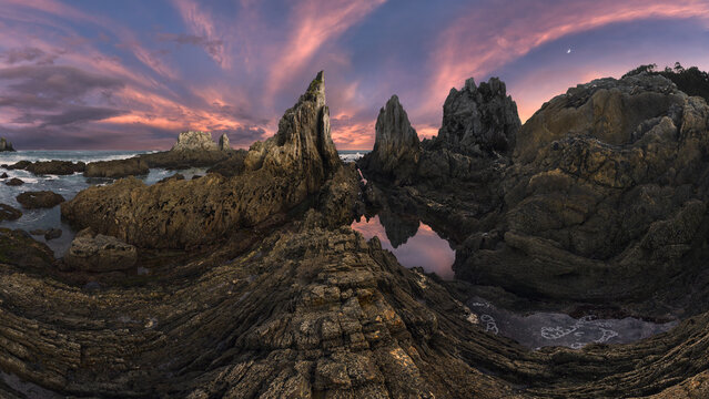 Dramatic Asturian rocky coast at twilight with tide pools