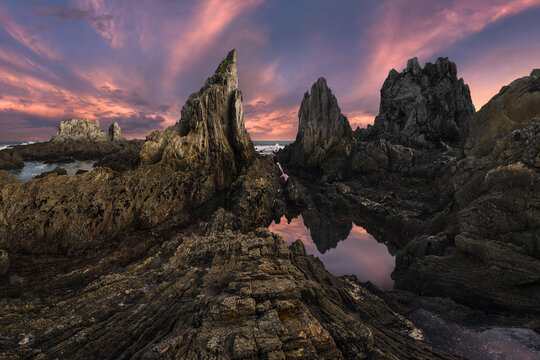 Dramatic Asturian seascape with jagged rocks at sunset