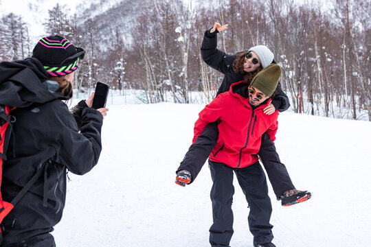 Friends posing for a snowy photo at a Japan ski resort