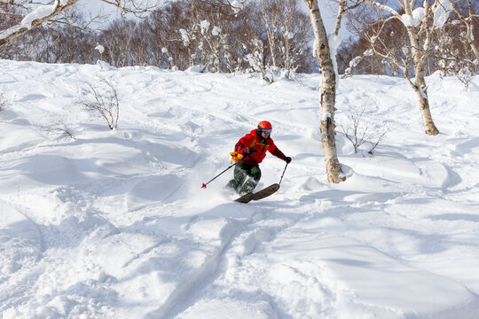 Skier carving through Niseko powder snow in Hokkaido, Japan