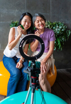 Mother and daughter filming skincare tutorial with ring light