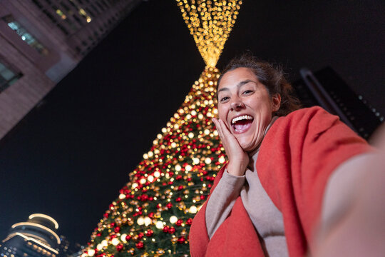 Woman taking selfie by giant Christmas tree lights in China