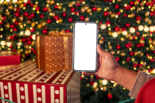 Smartphone mockup in hand with Christmas tree bokeh lights