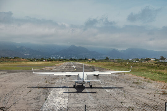 Small aircraft on runway with mountain backdrop