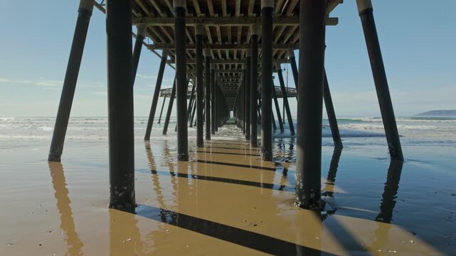 Symmetrical perspective underneath pismo beach pier in sunny california