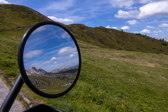 Mirror reflecting Dolomites peaks and alpine meadow