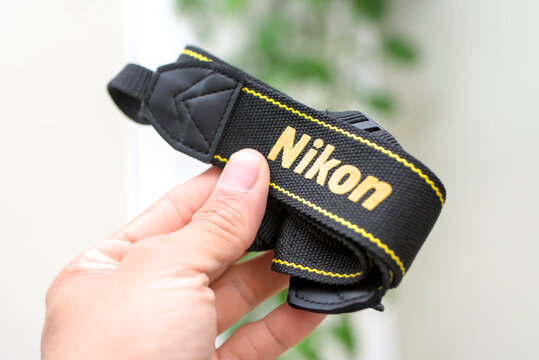 ZAPOPAN, MEXICO - JULY 25, 2026: Hand holding a black Nikon camera strap.