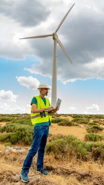 Wind turbine technician monitoring renewable energy output