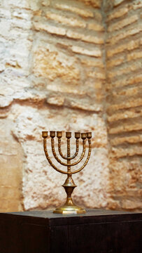 Brass menorah on stone wall in Cordoba, Andalusia