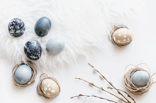 Pastel Easter eggs in nest on white background