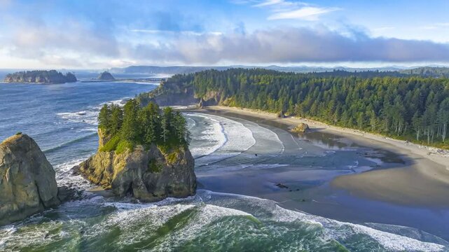 Aerial drone flying forward over sea stacks and waves crashing at Second Beach in La Push, Washington