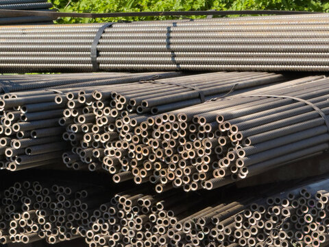 Stacked steel rebar rods bundled at an outdoor depot