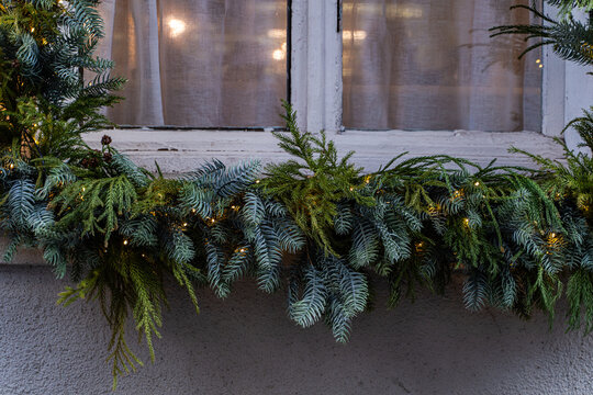 Christmas house window decorated with pine garland lights