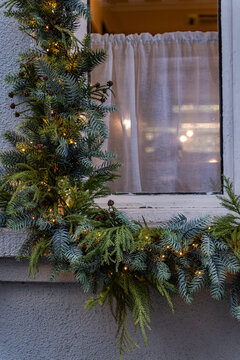 Christmas evergreen garland with warm lights on window
