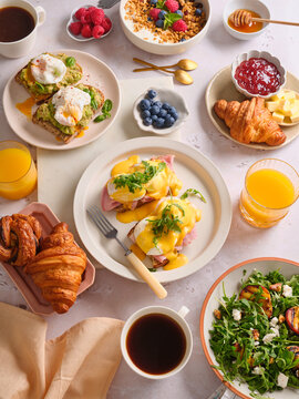 Brunch spread with egg benedict and avocado sandwich