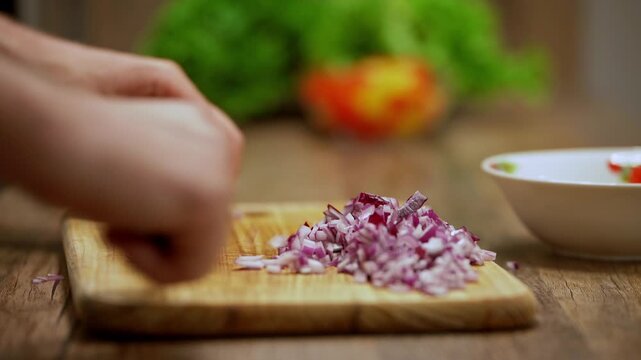 Realistic close-up of a man preparing ingredients by finely chopping onion on a wooden board. The home kitchen scene represents fresh cooking, natural ingredients, traditional meal preparation.
