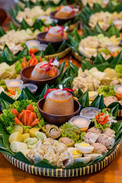 Traditional siomay Bandung with dumplings, egg, potato and peanut sauce served on banana leaf platter, authentic Indonesian Asian street food catering concept