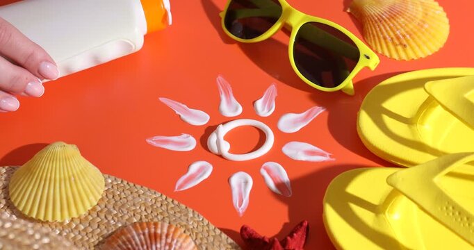 Woman putting bottle on sun protection product, sun made with sunscreen and beach accessories on bright orange background, closeup