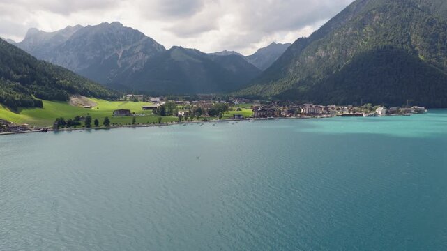 Drone view of turquoise Lake Achensee and Pertisau village surrounded by the Austrian Alps