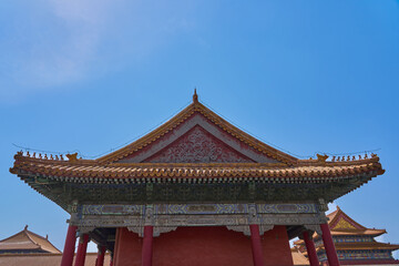 Fototapeta premium Ornate Traditional Chinese Palace Roof with Intricate Architectural Details Under Clear Blue Sky