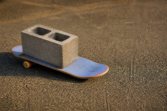 Skateboard with Concrete Block on Rough Asphalt