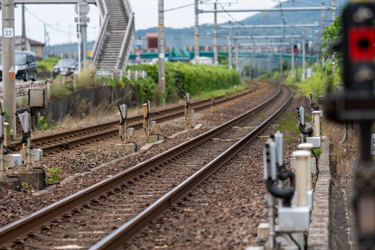 郊外を走る鉄道線路と信号設備のある日本の鉄道インフラ風景
