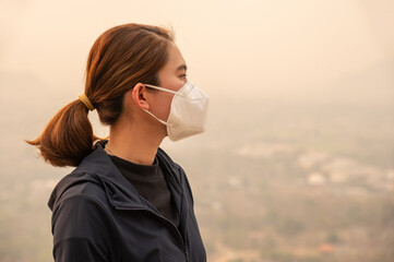 Asian woman wearing N95 mask for protect Bad air pollution (PM2.5). PM2.5 levels meaning the air quality posed a health hazard.
