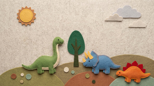 Handcrafted felt illustration featuring three colorful stitched dinosaurs, a tree, sun, and clouds on rolling hills.