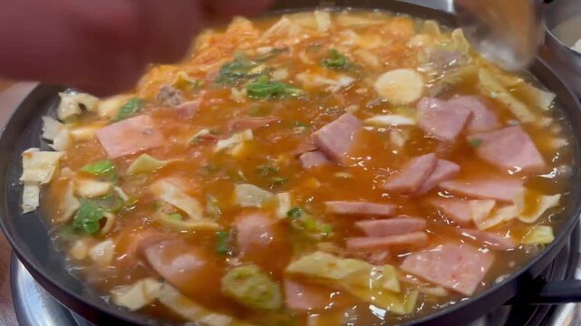 Delicious spicy Korean army stew budae jjigae boiling