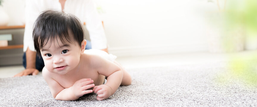 ハイハイする赤ちゃんを見守る父親 育児・子育て・成長・親子のふれあいのイクメン育休パパと赤ちゃんのイメージのバナー