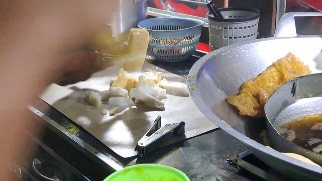 Indonesian street vendor making Tahu Tek Telur. Process includes whisking egg, frying omelette and tofu, cutting lontong with scissors, and making peanut petis sauce. Authentic Surabaya street food.