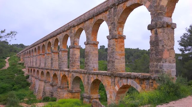Ancient roman aqueduct bridge known as ferreres aqueduct near tarragona in spain during cloudy day.