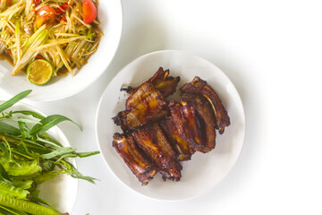Grilled pork ribs with som tam and fresh vegetables © angintaravichian