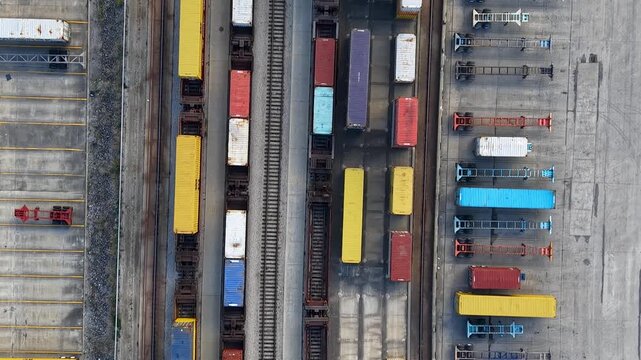 Aerial view of a gantry crane loading containers onto a freight train