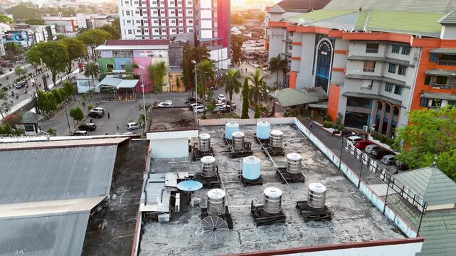 The view of the building's rooftop reveals a number of water tanks and antennas at afternoon