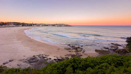 Obraz premium Bondi Beach at sunset with warm evening light over the Pacific Ocean and Sydney's iconic coastline in New South Wales, Australia.