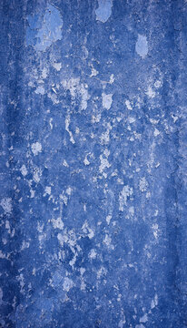 Distressed blue plaster texture with peeling paint effects and blue grunge texture background