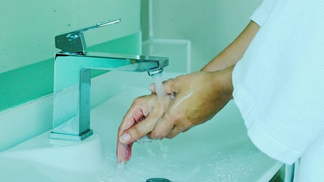 hand of beauty woman wash your hands at the wash basin with foam, cleanse the skin and have water flowing through the hands. Health and beauty concepts	