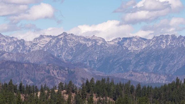 Aerial of Okanogan Wenatchee National Forest snow capped Stuart Range with panoramic view in summer with blue sky and clouds in Washington
