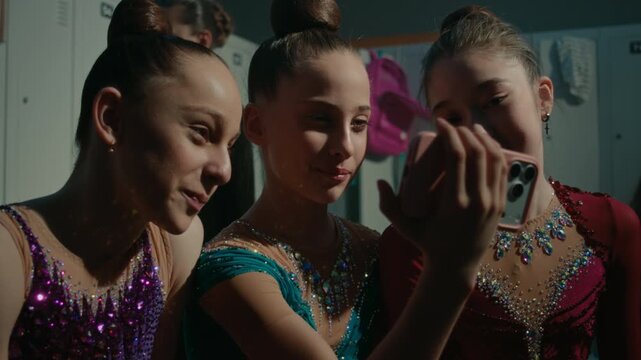 Three Teenage Sitting Together and Looking at Mobile Screen. Girl in Great Mood Exchanging Supportive Looks While Reviewing Performance. Healthy Competitive Spirit, Mutual Support, Camaraderie.