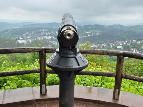 Coin operated tower viewer telescope above a misty green valley town in Eisenach, Germany