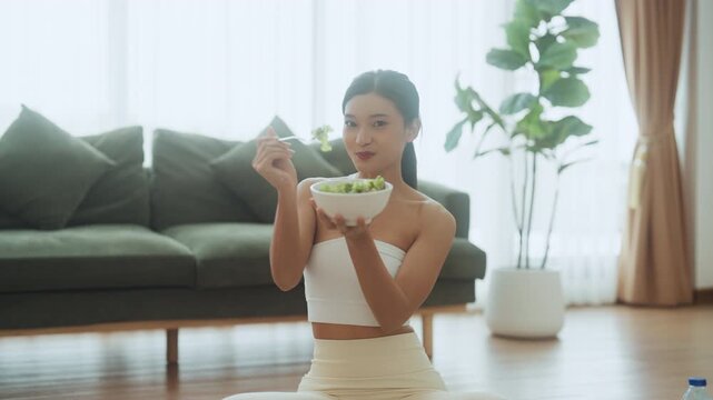 Healthy Asian Woman Enjoying Fresh Salad at Home After Yoga Workout