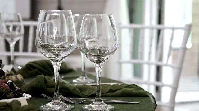 Elegant table setting with empty wine glasses, cutlery and stylish table linen prepared for wedding reception, restaurant service or formal celebration. Luxury dining concept.