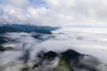 Fototapeta premium Landscape of Morning Mist with Mountain Layer. mountain ridge and clouds in rural jungle bush forest