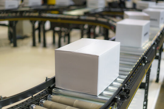 Blank White Box on Conveyor Belt in Warehouse